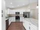 Bright kitchen featuring stainless steel appliances, granite countertops, and white cabinets at 9139 Se 155Th Pl, Summerfield, FL 34491