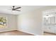 Bright main bedroom with hardwood floors, ceiling fan, and attached bathroom with updated vanity at 9139 Se 155Th Pl, Summerfield, FL 34491