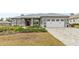 Gray house with white garage door, landscaped yard, and a paved driveway at 9287 Sw 102Nd Avenue Rd, Ocala, FL 34481