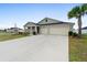 Light green house with a three car garage and palm trees at 9334 Sw 57Th Ave, Ocala, FL 34476