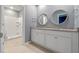 Double vanity bathroom with granite countertop and circular mirrors at 961 Lido Dr, Howey In The Hills, FL 34737