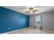 Bedroom with blue accent wall, ceiling fan, and window coverings at 961 Lido Dr, Howey In The Hills, FL 34737