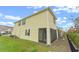 Tan house exterior with screened patio and grassy backyard at 961 Lido Dr, Howey In The Hills, FL 34737