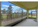 Screened porch overlooking backyard with a view of the surrounding landscape at 961 Lido Dr, Howey In The Hills, FL 34737