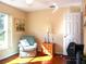 Bedroom with teal armchair and wooden flooring at 10108 Silver Bluff Dr, Leesburg, FL 34788