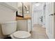 Bathroom with toilet, single sink and door to hallway at 12306 Ne 48Th Way, Oxford, FL 34484