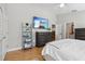Bright bedroom features a TV, ladder shelf, and wood floors at 12306 Ne 48Th Way, Oxford, FL 34484