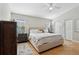 Bright bedroom with a plush bed, wood floors, and a ceiling fan at 12306 Ne 48Th Way, Oxford, FL 34484