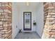 Inviting front entry with stone pillars and a gray door at 12306 Ne 48Th Way, Oxford, FL 34484