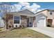 Inviting residence with a stone accent, lush landscaping, and an attached single-car garage at 12306 Ne 48Th Way, Oxford, FL 34484