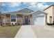 Charming single-Gathering home featuring a stone facade, well-maintained lawn, and attached garage at 12306 Ne 48Th Way, Oxford, FL 34484