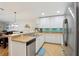 Spacious kitchen featuring stainless steel appliances, white cabinets, and convenient breakfast bar seating at 12306 Ne 48Th Way, Oxford, FL 34484