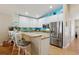 Modern kitchen features white cabinets, stainless steel appliances, breakfast bar and adjacent eat-in area at 12306 Ne 48Th Way, Oxford, FL 34484
