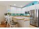 Bright kitchen featuring white cabinets, stainless steel appliances, and an eat-in bar perfect for casual dining at 12306 Ne 48Th Way, Oxford, FL 34484