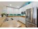 Modern kitchen with stainless steel appliances, stylish backsplash, ample counter space, and efficient lighting at 12306 Ne 48Th Way, Oxford, FL 34484