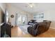 Spacious living room featuring comfortable leather seating, beach decor, and abundant natural light at 12306 Ne 48Th Way, Oxford, FL 34484