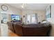 Comfortable living room with a leather recliner sofa, mounted TV, and access to outdoor space at 12306 Ne 48Th Way, Oxford, FL 34484