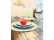 A beautifully set dining table ready for guests with floral plates, seashell accents and margarita glasses at 12306 Ne 48Th Way, Oxford, FL 34484