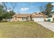 Tan house with a two-car garage and well-maintained lawn at 1381 Winterville St, Deltona, FL 32725