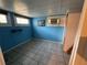 Unfinished basement room with blue walls and window at 13920 S Highway 25, Eastlake Weir, FL 32133