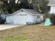 White detached garage with a single overhead door and side window at 13920 S Highway 25, Eastlake Weir, FL 32133