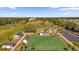 Aerial view of a community park, featuring a lawn bowling green, putting green, and wooded perimeter at 16967 Se 93Rd Cuthbert Cir, The Villages, FL 32162