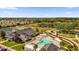 An aerial view highlighting a pool, tennis courts, clubhouse, and surrounding neighborhood at 16967 Se 93Rd Cuthbert Cir, The Villages, FL 32162