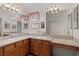 Double vanity bathroom with light wood cabinets and corner sinks at 17030 Se 79Th Clearview Ave, The Villages, FL 32162