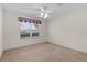 Well-lit bedroom with ceiling fan, window, and carpet flooring at 17030 Se 79Th Clearview Ave, The Villages, FL 32162