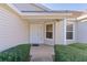 Front entry with a white door and sidelights, flanked by bushes at 17030 Se 79Th Clearview Ave, The Villages, FL 32162