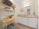 Charming bathroom with white vanity, shelving, and linen storage at 1706 Pebble Beach Ln, Lady Lake, FL 32159