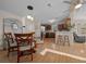 Open dining area with kitchen view, wooden table and chairs, and hardwood floors at 1706 Pebble Beach Ln, Lady Lake, FL 32159