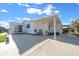 White home exterior with covered patio and seating area at 1706 Pebble Beach Ln, Lady Lake, FL 32159