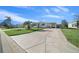 Front view of a white mobile home with a large driveway at 1706 Pebble Beach Ln, Lady Lake, FL 32159