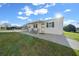 White single-wide mobile home with covered patio and well-maintained lawn at 1706 Pebble Beach Ln, Lady Lake, FL 32159