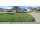 Landscaped yard with driveway leading to a tan mobile home at 1706 Pebble Beach Ln, Lady Lake, FL 32159