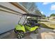 Lime green golf cart parked outside the garage, showing off the desirable neighborhood and community at 17430 Se 115Th Terrace Rd, Summerfield, FL 34491