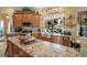 Close-up of kitchen island with granite countertop, stainless steel sink and wood cabinets at 17430 Se 115Th Terrace Rd, Summerfield, FL 34491