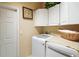 Convenient laundry room featuring a washer and dryer and upper cabinets at 17430 Se 115Th Terrace Rd, Summerfield, FL 34491