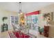 Bright dining room with glass table, red rug, and view to backyard at 2134 Zaragoza Pl, Lady Lake, FL 32159