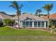 House exterior showcasing a large sunroom and well-manicured lawn at 2134 Zaragoza Pl, Lady Lake, FL 32159