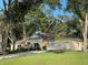 Tan house with brown roof, landscaping, and a two-car garage at 214 Forest Park Ln, Lady Lake, FL 32159