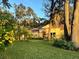 Tan house nestled among lush greenery and mature trees at 214 Forest Park Ln, Lady Lake, FL 32159