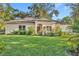 Tan house with brown roof, landscaping, and a two-car garage at 214 Forest Park Ln, Lady Lake, FL 32159