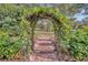 Brick pathway leads to a lush garden arch at 214 Forest Park Ln, Lady Lake, FL 32159