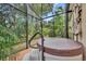 Hot tub in a screened enclosure with surrounding foliage at 214 Forest Park Ln, Lady Lake, FL 32159