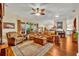 Living room with hardwood floors, leather couches, and access to the kitchen at 214 Forest Park Ln, Lady Lake, FL 32159