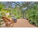 Relaxing screened porch with wicker chairs and lush landscaping at 214 Forest Park Ln, Lady Lake, FL 32159