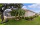 Landscaped backyard with lush greenery and screened patio at 2240 Avon Loop, The Villages, FL 32162