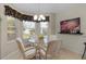 Bright kitchen nook with glass table and four chairs at 2240 Avon Loop, The Villages, FL 32162